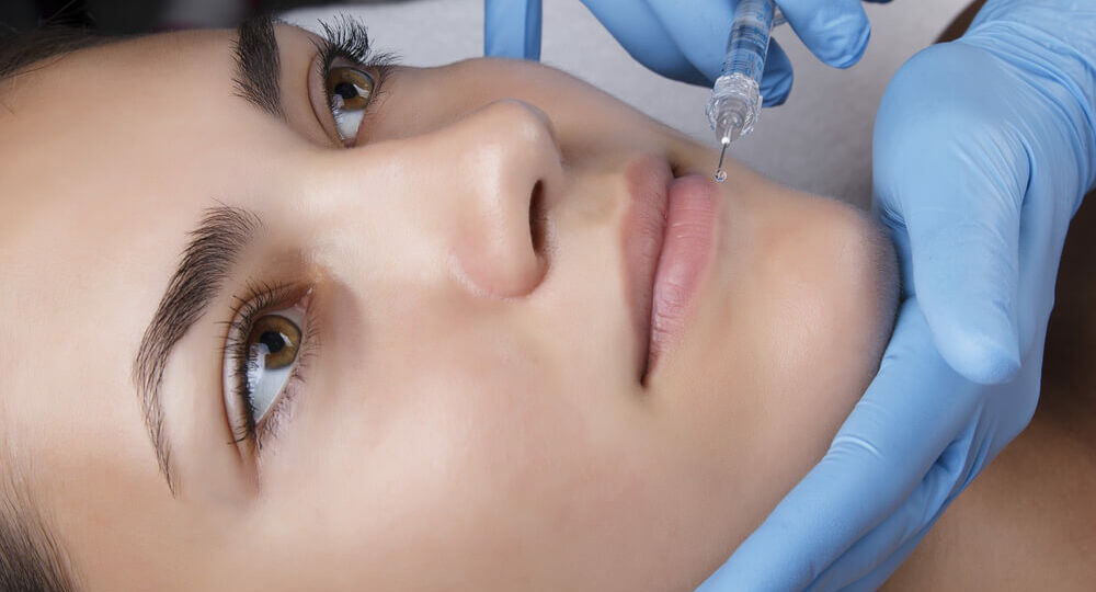 A woman getting her face waxed at the salon