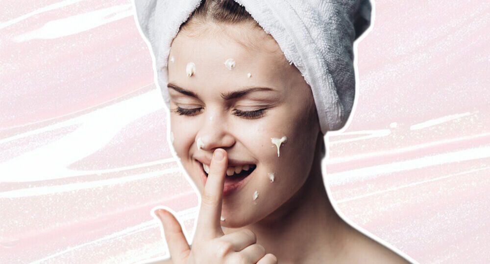 A woman with a towel on her head and finger in her mouth.