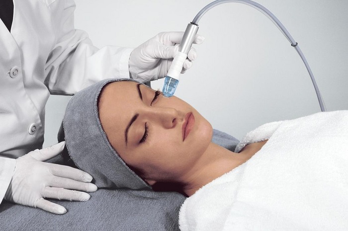 A woman getting her face cleaned by an esthetician.