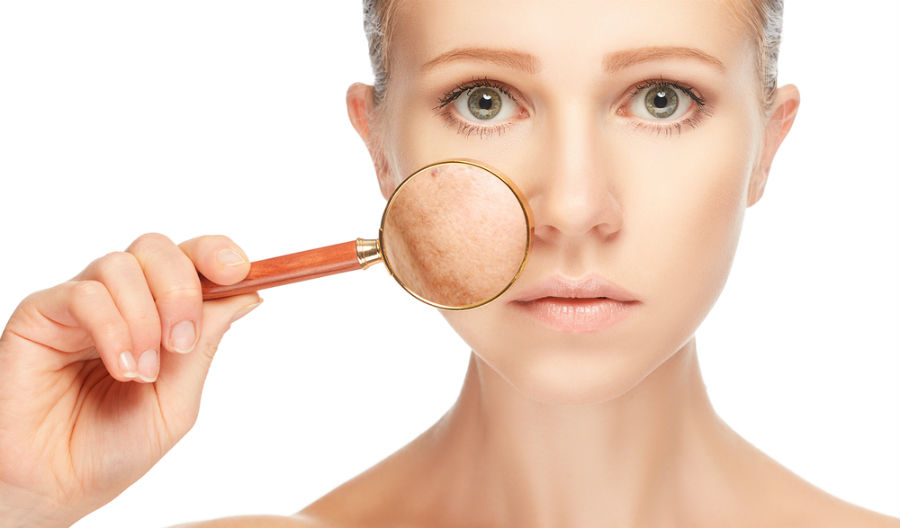 A woman holding a magnifying glass up to her face.