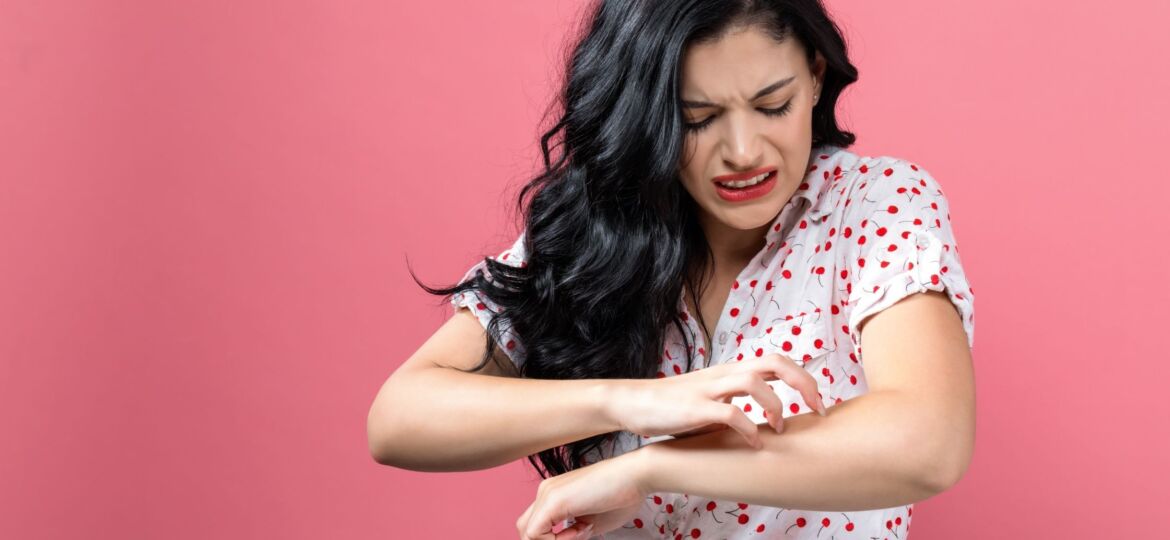 A woman is holding her arm up to the side of her face.